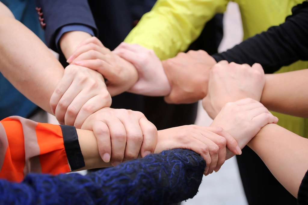 Hands joining together in a circle of support